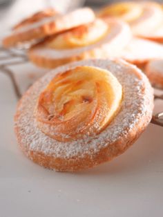 powdered sugar covered pastries sitting on top of a white plate