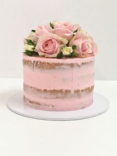 a cake with pink frosting and flowers on top