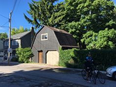 a bicyclist rides past a garage on a residential street