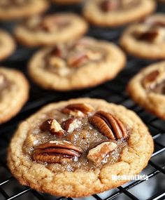 a cookie with pecans on top is cooling on a rack in front of other cookies