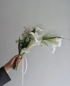 a hand holding a bouquet of white flowers