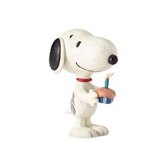 a figurine of a snoopy holding a cupcake and a candle in his hand