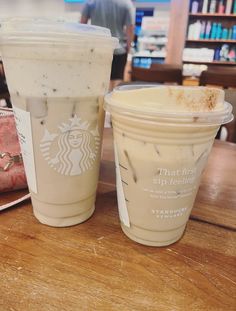 two starbucks drinks sitting next to each other on a table