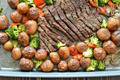 steak, potatoes and broccoli on a sheet pan with meatballs in the middle