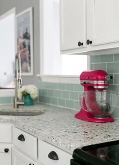 a pink mixer sitting on top of a kitchen counter