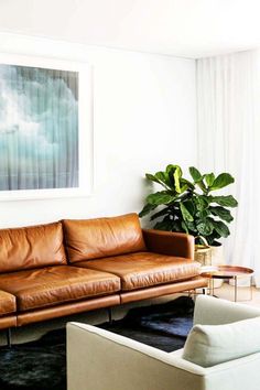 a living room filled with furniture and a painting on the wall