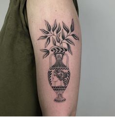 a black and white vase tattoo on the arm