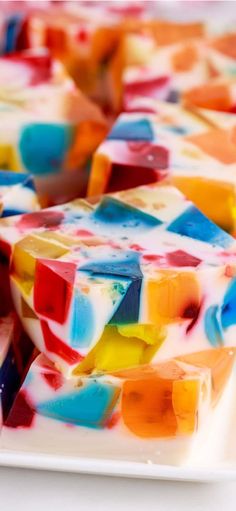 multicolored soap bars stacked on top of each other in a white dish with one bar missing