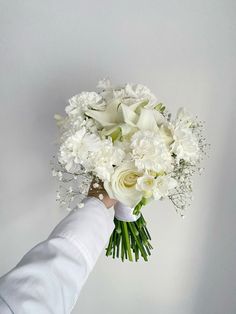 a person holding a bouquet of white flowers