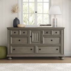 a gray dresser sitting in front of a window