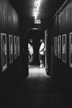 black and white photograph of two men standing in an exit