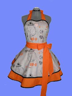 a dress with an orange bow on the front and back, sitting on top of a mannequin