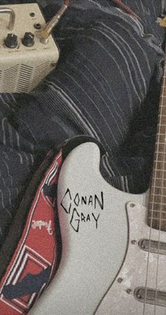 an electric guitar and some other musical instruments are laying on top of a person's bed