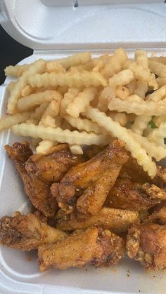 chicken wings and waffle fries in a styrofoam container