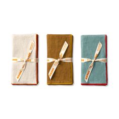 three folded napkins tied with ribbon in different colors