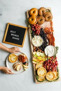 a platter filled with fruit and pastries next to a sign that says best brunch board