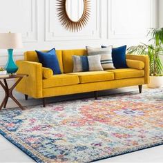 a yellow couch sitting on top of a rug in a living room