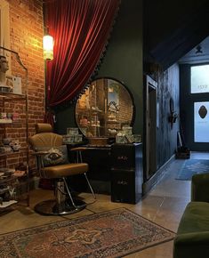 a room with a chair, mirror and rug on the floor in front of a brick wall