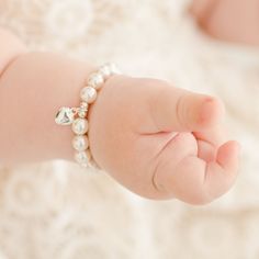 Close-up of a baby's tiny hand with a Baby Beau & Belle White Luster Pearl Bracelet with Silver Heart Charm, resting on a soft, textured blanket. Baby Heart, White Pearl Bracelet, Heirloom Gifts, Baby Jewelry, Flower Girl Gifts, First Birthday Gifts, Gifts Baby, Tin Gifts, Perfect Baby Shower Gift