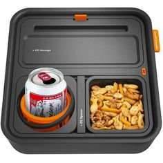 an orange and black lunch box with two cans of soda, nuts and peanuts in it