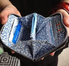 a person holding an open wallet with credit cards in it