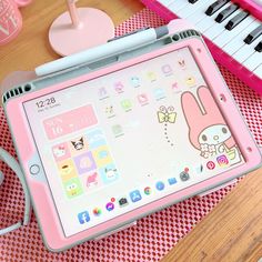 a pink tablet sitting on top of a wooden table next to a keyboard and mouse