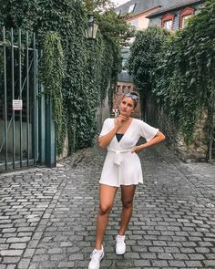 a woman is standing in the middle of an alley