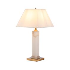 a white lamp with a gold base and a light shade on the top of it