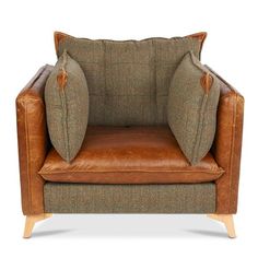 a brown leather chair with two pillows on it's back and one arm facing the camera