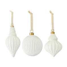 three white ornaments hanging from wooden hooks