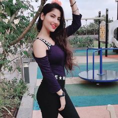 a woman posing for the camera in front of a playground