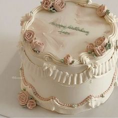 a white cake with pink roses on top