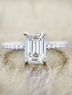 an emerald cut diamond ring with pave set shoulders