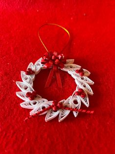 a christmas ornament is hanging on a red carpet with a ribbon around it