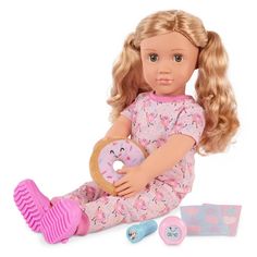 a doll sitting on the ground with a doughnut and hair brush in her hand