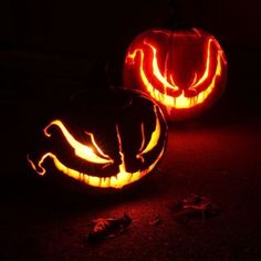 two carved pumpkins sitting on top of a table