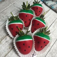 four chocolate covered strawberries with green and white stripes on them are arranged in the shape of strawberrys