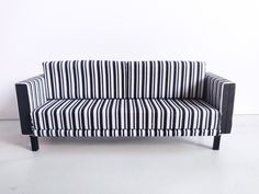 a black and white striped couch sitting on top of a floor