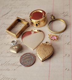 Seven assorted metal (brass goldtone) Findings. Coin holders, hinged frame, hearts and pink lucite charm. Please expect aging and overall glorious character.  You'd receive all 7 pieces  Thank you for looking! Brass Trinkets, Hinged Frame, Coin Holder, Locket Charms, Jewelry Photography, Shop Ideas, Charm Jewelry, Vintage Brass, Locket