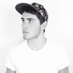 black and white photograph of a young man wearing a baseball cap looking to the side