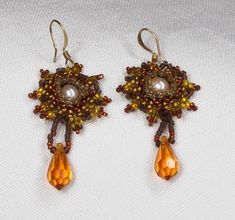 Fall color beaded earrings with a white pearl and a crystal gold colored drop. The earrings are 1 1/2". Gold Beaded Teardrop Pearl Earrings, Gold Dangle Beaded Earrings With Bead Caps, Gold Beaded Dangle Flower Earrings, Beaded Flower Earrings, Hazel Green, Fall Color, White Pearl, Flower Earrings, Pearl White