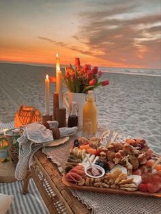 a table with food and candles on the beach