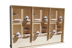 four wooden bird cages sitting on top of each other in front of a white background