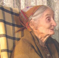 an old woman sitting on top of a couch