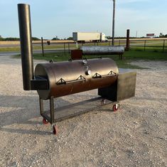 a large metal grill sitting on top of a gravel field