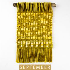 an image of a weaving project with the words september written in gold and white on it