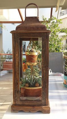 an old wooden lantern with plants in it