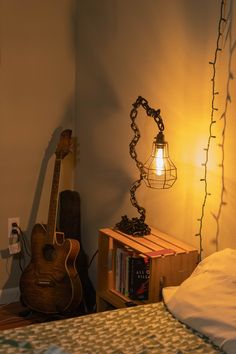 a bedroom with a bed, guitar and lamp on the side table next to it