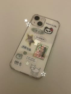 an iphone case with various stickers and pictures on the back, sitting on top of a table