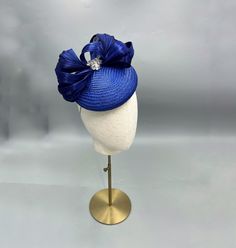 Fabulous royal blue percher hat, suitable for a wedding, garden party or trip to the races. The button base is created from a lovely royal blue straw. It has been adorned with silk abaca bow and sparkly diamanté motif.  The base has been fully lined. Secured to the head with elastic. Come delivered in a luxury hat box. Kentucky Derby Party Hat With Satin Bow, Kentucky Derby Evening Hat With Satin Bow, Evening Hat With Bow For Royal Ascot, Kentucky Derby Formal Fascinator With Satin Bow, Kentucky Derby Satin Bow Fascinator, Kentucky Derby Formal Mini Hat With Bow, Formal Mini Hat With Bow For Kentucky Derby, Formal Kentucky Derby Headpiece With Bow, Formal Bow Headpiece For Kentucky Derby